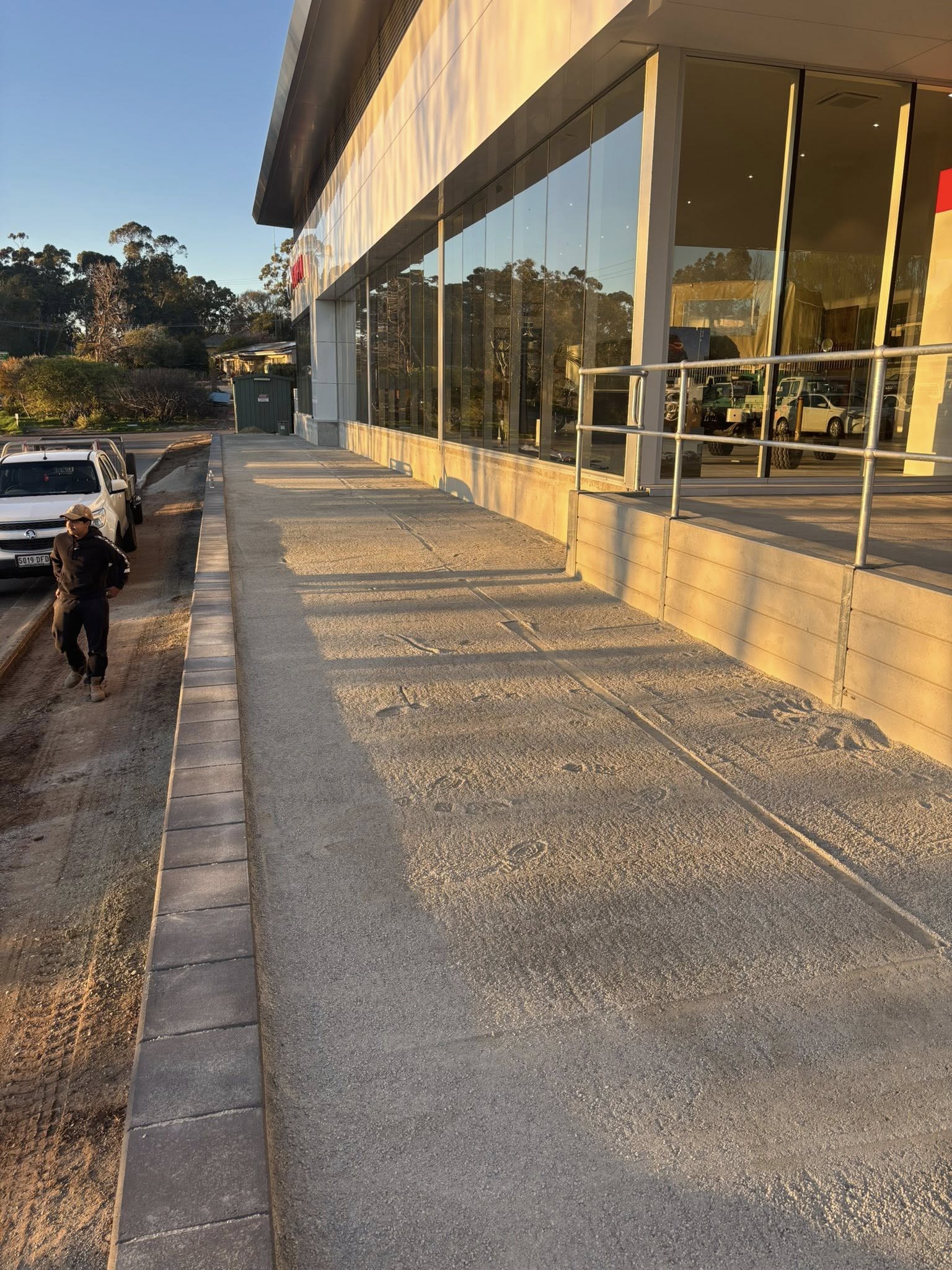 Commercial shopfront before — bare concrete path at Nissan dealership