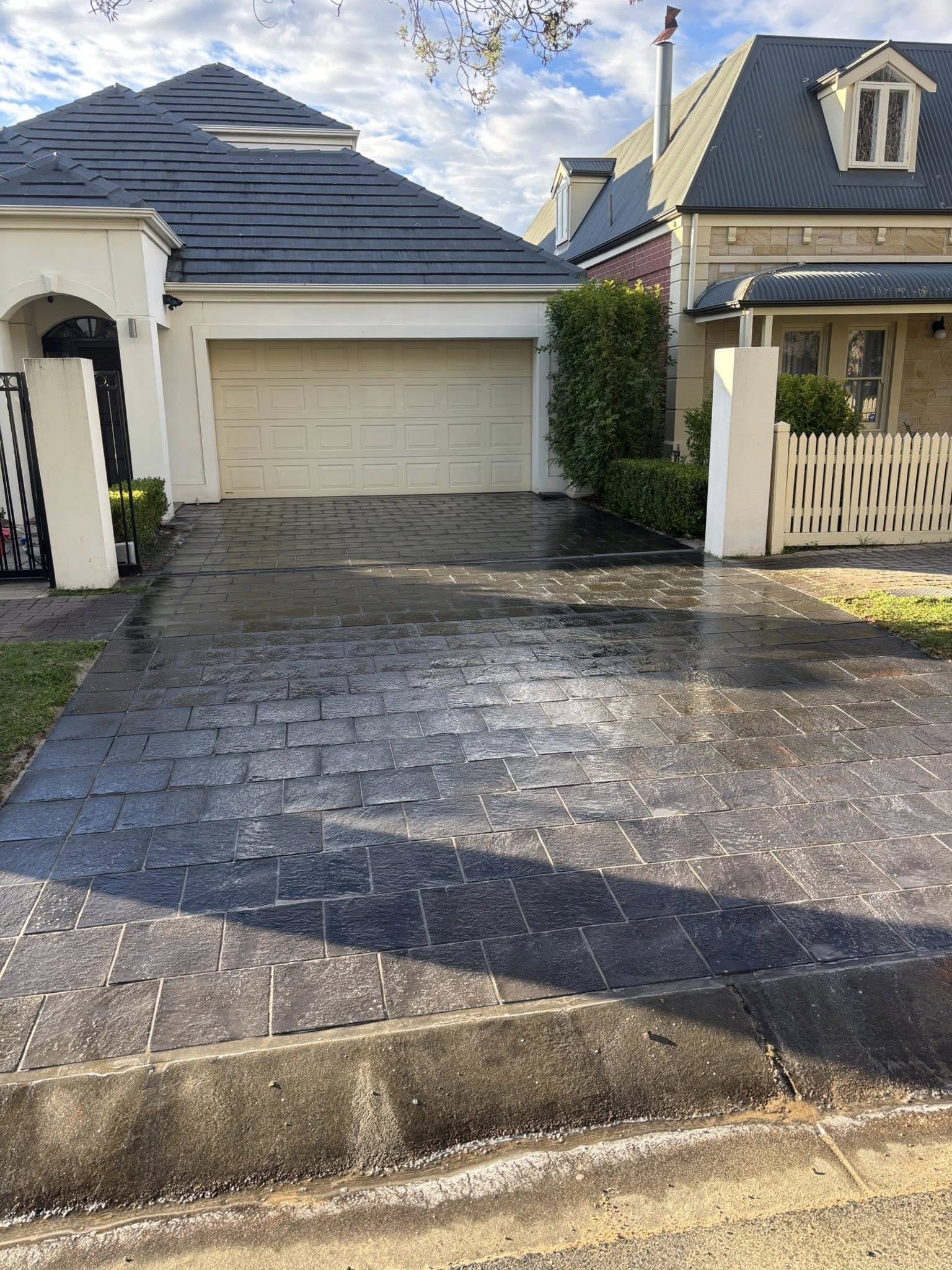 Charcoal brick driveway at premium Adelaide home — wet-laid dark pavers