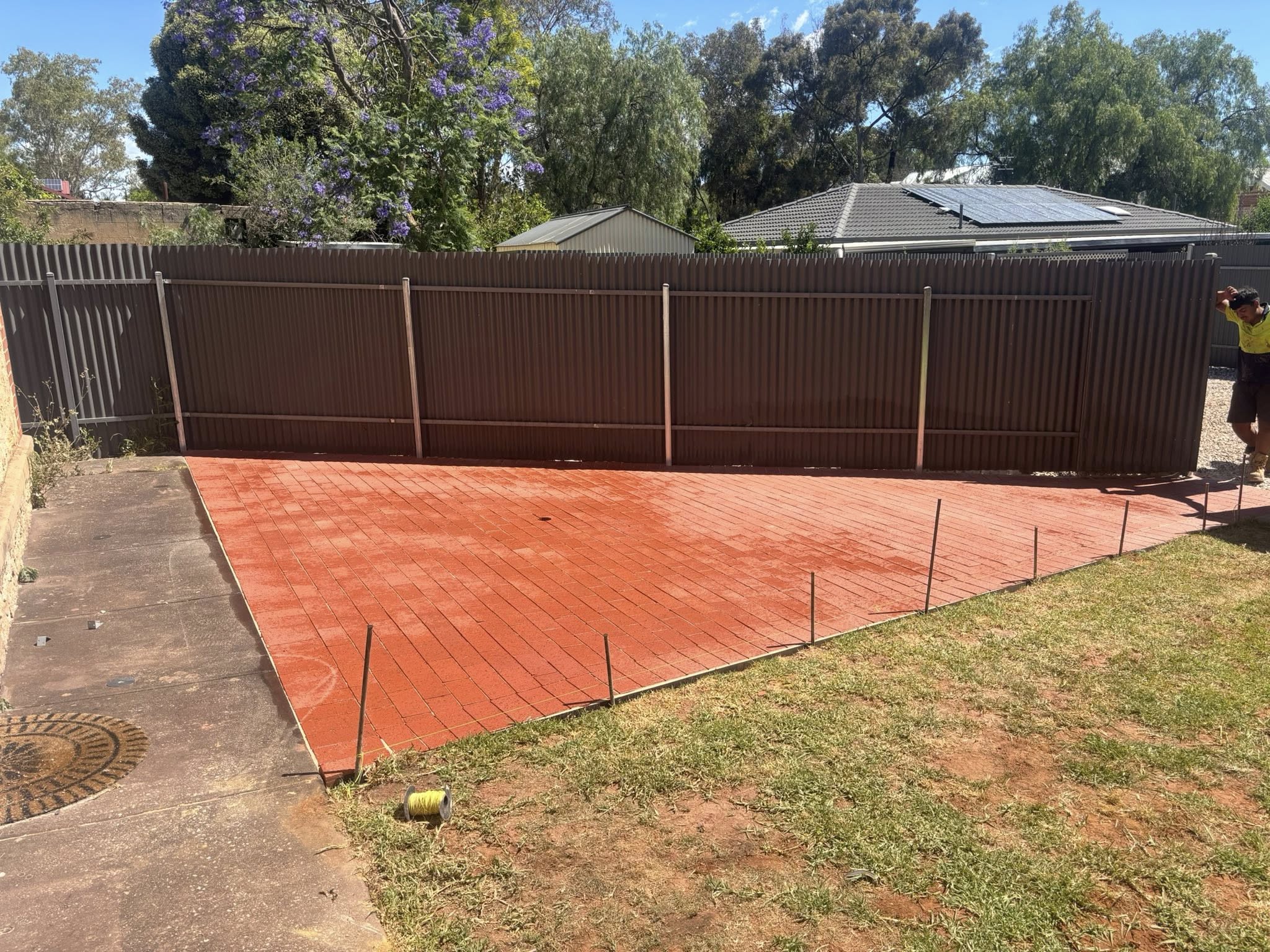 Red brick herringbone backyard paving — residential patio installation