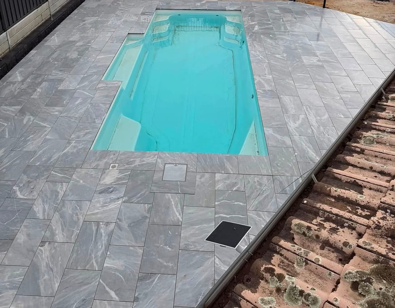 Elevated view of the full fibreglass pool and new marble-look paving